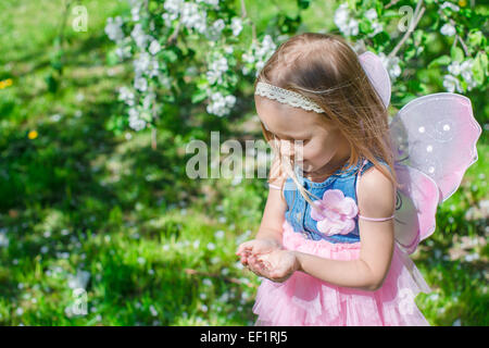 Bambina con una coccinella nelle mani durante la fioritura apple Orchard Foto Stock