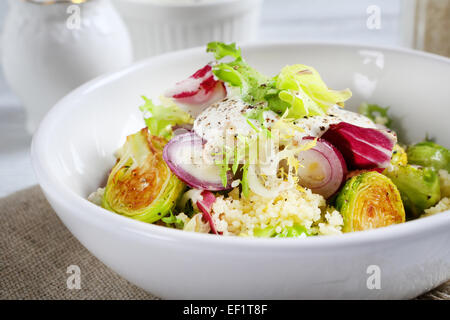 Una sana insalata con il cous cous in una ciotola, cibo Foto Stock