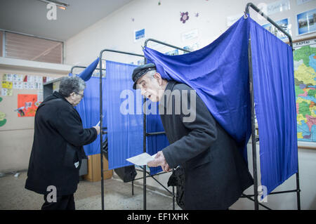 Atene, Grecia. 25 gennaio, 2015. Un elettore lascia una vota per gettare il suo scrutinio per Grecce elezioni generali in Atene, Grecia, 25 gennaio 2015. La Grecia di sinistra, anti-austerità Syriza partito e il suo leader Alexis Tsipras, ha ampliato la propria leadership nella parte superiore per il 25 gennaio 2015 elezioni- a cavallo di un onda di rabbia su misure di austerità imposto come condizione per un salvataggio internazionale. Foto: Michael Kappeler/dpa/Alamy Live News Foto Stock