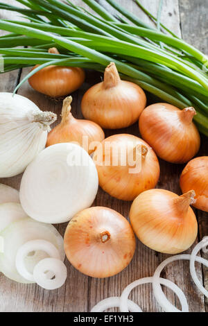 Diverse le cipolle su legno tavolo rustico Foto Stock