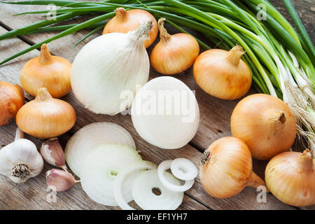 Diverse le cipolle e aglio lampadina sul rustico in legno tabella Foto Stock