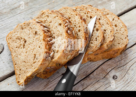 Fette di pane di segale e il coltello sul tavolo da cucina Foto Stock