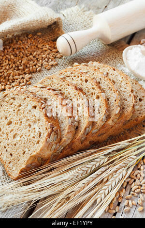 Le fette di pane, mattarello, grano e segale orecchie sul tavolo da cucina Foto Stock