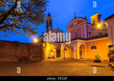 Due chiese sulla piccola piazza in ciottoli di mattina presto nella città di Barolo, Italia. Foto Stock