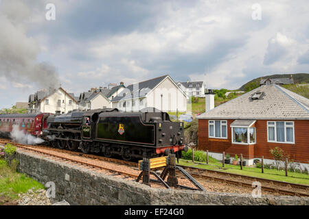 Giacobita treno a vapore passando vicino alle case sul West Highland linea ferroviaria a Fort William. Mallaig Highland Scozia UK Gran Bretagna Foto Stock