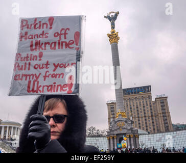 Kiev, Ucraina. 25 gennaio, 2015. Indifferente ucraino detiene una targhetta contro l aggressione russa. -- Oggi. 25 gennaio 2014, presso la piazza Indipendenza a Kiev in Ucraina, ha onorato la memoria di coloro che sono morti in Mariupol.ieri il russo-truppe terroristiche sparato Mariupol, Donetsk regione del lancio di molteplici sistemi di razzo "Grad". Secondo recenti rapporti, uccidendo almeno 30 persone e il ferimento di circa un centinaio di. Credito: Igor Golovnov/Alamy Live News Foto Stock