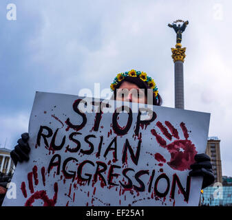 Kiev, Ucraina. 25 gennaio, 2015. Indifferente ucraino detiene una targhetta contro l aggressione russa. -- Oggi. 25 gennaio 2014, presso la piazza Indipendenza a Kiev in Ucraina, ha onorato la memoria di coloro che sono morti in Mariupol.ieri il russo-truppe terroristiche sparato Mariupol, Donetsk regione del lancio di molteplici sistemi di razzo "Grad". Secondo recenti rapporti, uccidendo almeno 30 persone e il ferimento di circa un centinaio di. Credito: Igor Golovnov/Alamy Live News Foto Stock