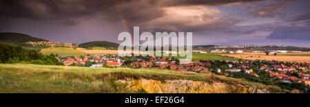 Paesaggio con diverse aree popolate sotto il cielo nuvoloso e Rainbow Foto Stock