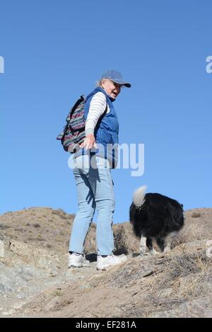 Un anziano con il suo cane quasi alla sommità della ripida salita in montagna vicino a Albuquerque, Nuovo Messico Foto Stock