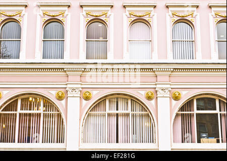 Finestre ad arco in un edificio rosa NEL REGNO UNITO Foto Stock