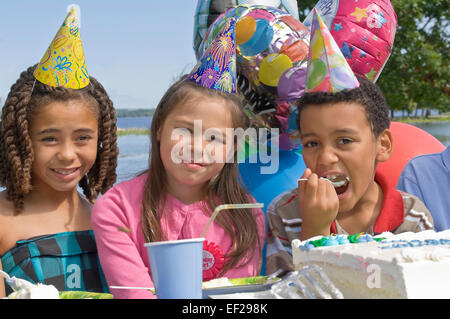 I bambini a mangiare la torta di compleanno Foto Stock