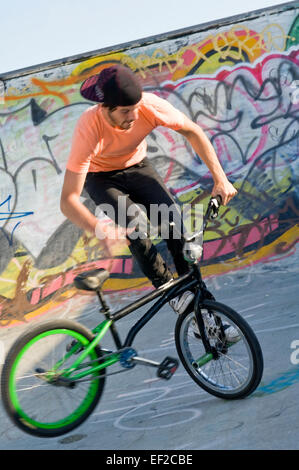 Un giovane uomo in una skatepark facendo trucchi sulla sua bicicletta Foto Stock