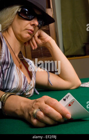 Femmina giocatore di poker in possesso di una coppia di assi Foto Stock