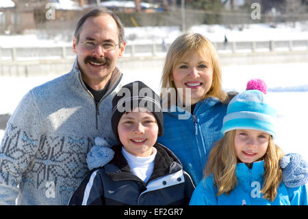 La famiglia in posa all'aperto in inverno Foto Stock