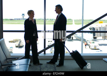 Due uomini di affari che in un aeroporto Foto Stock