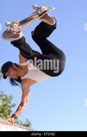 Guidatore di skateboard facendo antenne a un skate park Foto Stock