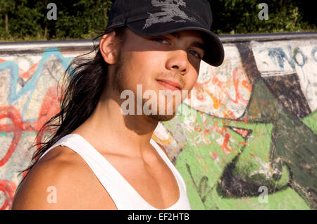 Guidatore di skateboard appendere intorno a skate park Foto Stock