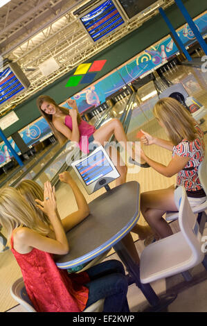 Ragazza amici a una tabella in un impianto da bowling Foto Stock