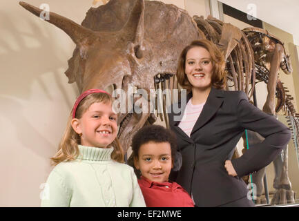 L insegnante e gli studenti nel museo da fossili di dinosauro display Foto Stock