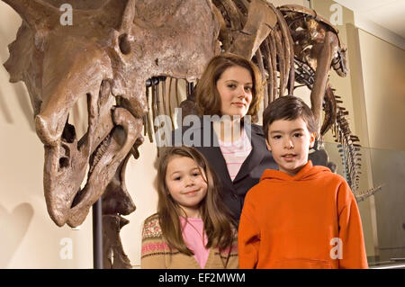 L insegnante e gli studenti nel museo da fossili di dinosauro display Foto Stock