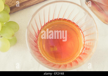 Whisky in un bicchiere e uva sulla tavola vista superiore Foto Stock