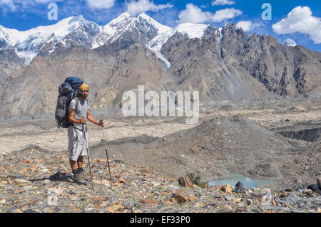 Giovane escursionista con zaino grande sul ghiacciaio Engilchek con scenic Tian Shan mountain range in Kirghizistan Foto Stock