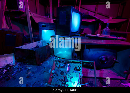 Luce dipinta abbandonato cinema studio. 3 si è schiantato TV Imposta ancora splendente. Festa di Halloween sfondo Foto Stock