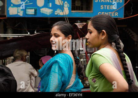 Le ragazze che hanno conversato durante una congestione del traffico mentre stanno guidando in bicicletta a Varanasi, Uttar Pradesh, India Foto Stock