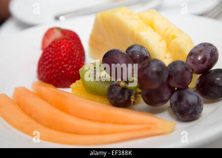 Piastra di fettine canteloupe, ananas e kiwi con fragole e uva Foto Stock