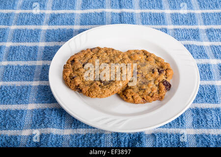 Due fiocchi d'avena fresca Uva passa i cookie su una piastra bianca Foto Stock