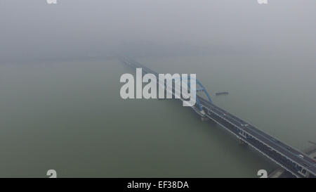 Hangzhou. 26 gen, 2015. Foto aeree prese a gennaio 26, 2015 mostra un ponte avvolta nel smog oltre il Fiume Qiantang in Hangzhou, a est della capitale cinese della Provincia di Zhejiang. La città è indice di qualità dell'aria (AQI) lettura a 14 p.m. Lunedì è stato 258. Molte parti della provincia rilasciato giallo e arancione avviso per lo smog lunedì. Credito: Xu Yu/Xinhua/Alamy Live News Foto Stock