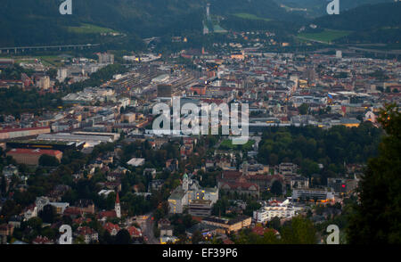 Paesaggio urbano di Innsbruck al tramonto, con la luce dorata che si riflette sulle vette alpine che circondano la città. Foto Stock