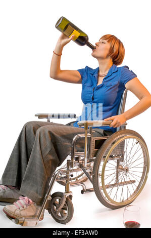 Una donna su una sedia a rotelle bere il vino dalla bottiglia Foto Stock