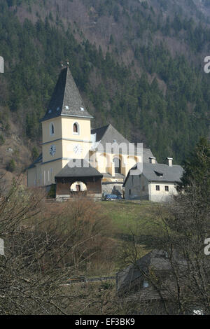 Questa fotografia cattura la Pfarrkirche Hollenstein an der Ybbs, una chiesa parrocchiale situata nella città di Hollenstein, in Austria. L'architettura e il significato storico della chiesa sono evidenziati in questa immagine, che mostra il suo ruolo nella comunità locale e il suo patrimonio religioso. Foto Stock