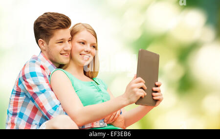 Coppia con tablet pc tenendo selfie su verde Foto Stock