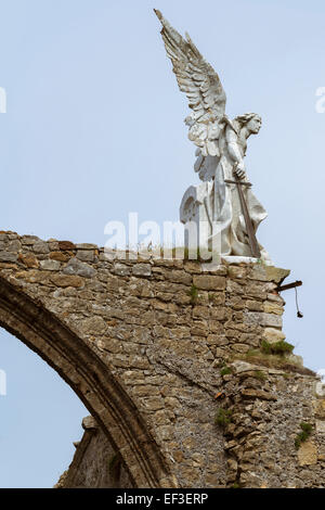 La scultura di un angelo custode su un arco in pietra, con una spada nel cimitero di Comillas. Cantabria - Spagna Foto Stock