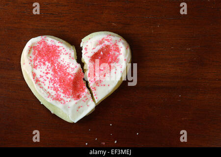 Cuore spezzato Cookie sagomata su un vecchio tavolo in legno Foto Stock