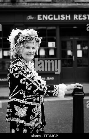 Regina di perla, indossando il tradizionale abiti cerimoniali coperto con dei bottoni di madreperla, classe operaia cultura, Londra UK (pearlies) b&W Foto Stock