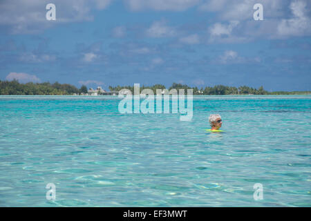 Polinesia francese Isole della Società, Isole Sottovento, Bora Bora. Donna nuotare nella laguna di chiara a Haapiti. Foto Stock