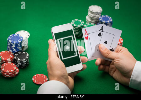 Casino player con cards, smartphone e trucioli Foto Stock