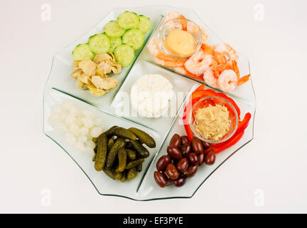 Vassoio di antipasti con carciofi,cetriolo,sottaceti,gamberetti,hummus,formaggio di capra,olive, dip Foto Stock