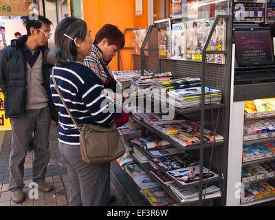 Hong Kong 2015 - persone la lettura di riviste di esplorazione in edicola Foto Stock