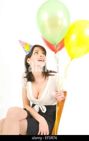Donna che indossa cappellino e palloncini di contenimento Foto Stock