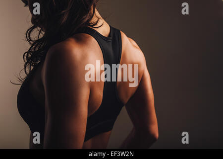 Vista posteriore del forte giovane donna indossa reggiseno per lo sport. Retro muscolare di una donna in abbigliamento sportivo. Foto Stock