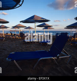 Sedie a sdraio e ombrelloni sulla spiaggia in una mattinata Foto Stock