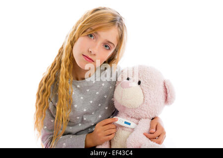 Ragazza bionda con Teddy bear termometro e influenza a freddo in pigiama Foto Stock