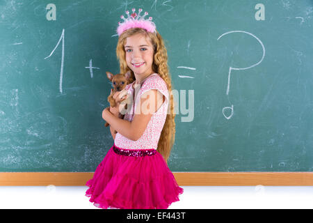 La principessa bionda schoolgirl azienda pet chihuahua cucciolo di cane in aula verde chalk board Foto Stock