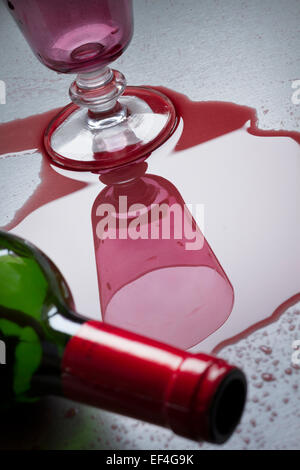 Bottiglia di vino rovesciato sopra accanto al vetro. Foto Stock