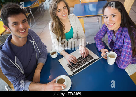 I giovani studenti di fare assegnazioni su laptop insieme Foto Stock