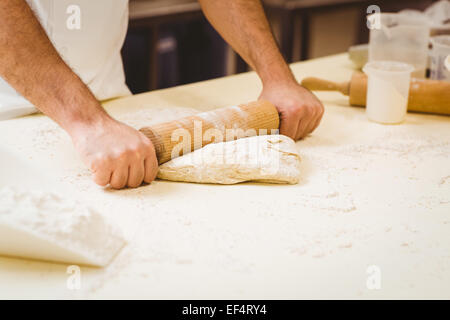 Baker pasta di laminazione in corrispondenza di un contatore Foto Stock